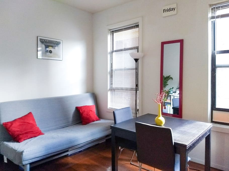 Living room with two windows, sofa and dinning table