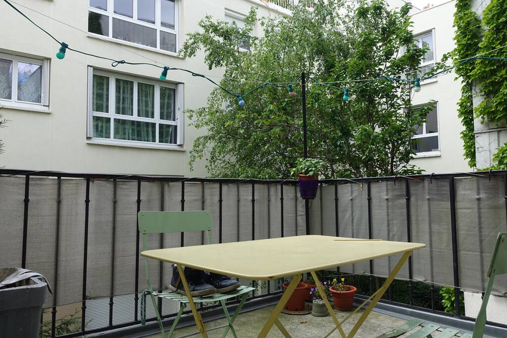 Grande terrasse ensoleillée avec table et chaises