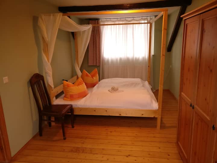 Dormitorio pequeño con cama tamaño queen.