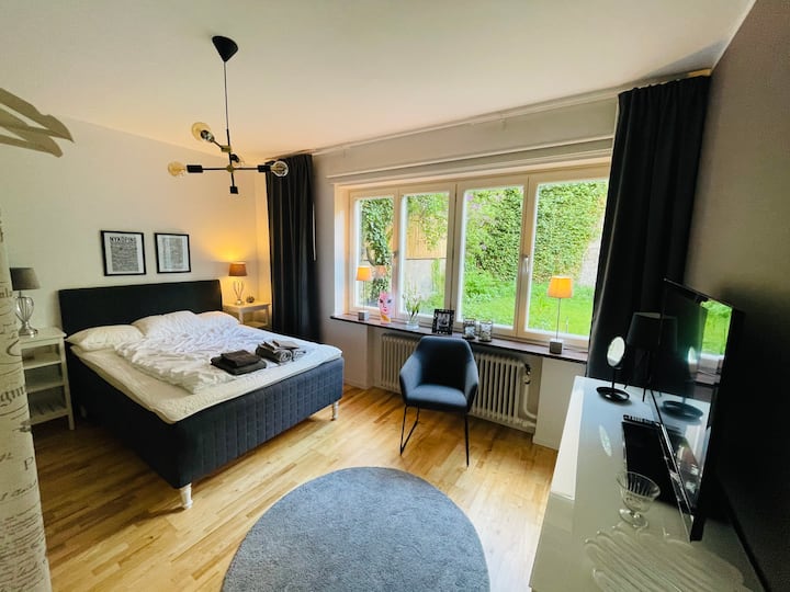 El dormitorio principal con una cama de 140 cm. Maravillosa vista de nuestro oasis al jardín. Chromecast/AppleTV en el dormitorio, secador de pelo, perchas y una caja para poner ropa. 