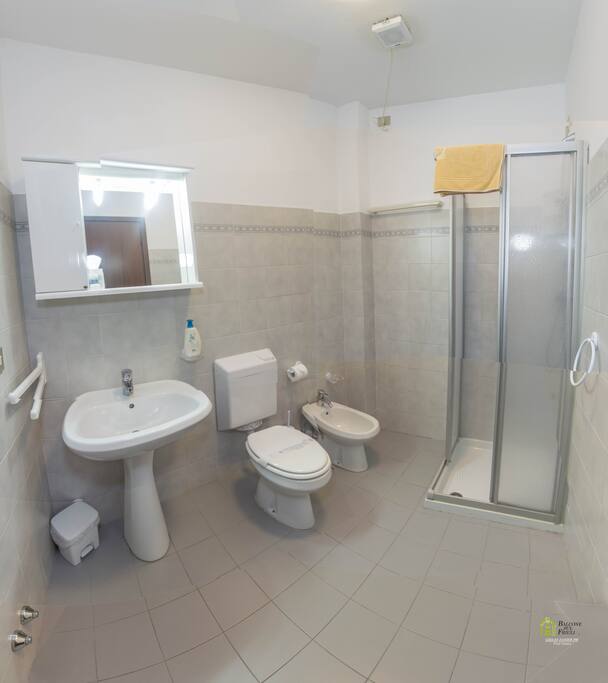 Bagno con box doccia, shampoo e saponette per le mani.