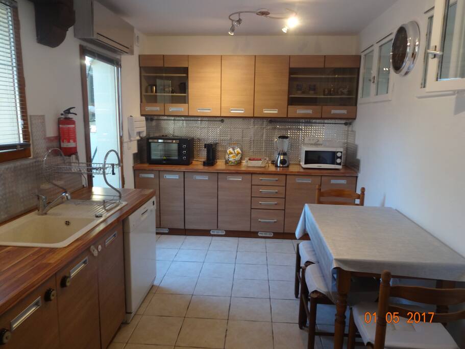 cuisine très spacieuse entièrement équipée. plaque de cuisson à gaz. frigo congélateur. lave vaisselle . table et chaises pour 4 personnes