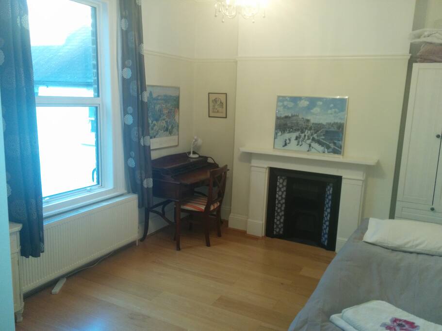 Room with decorative fireplace, wooden desk and views over the back garden