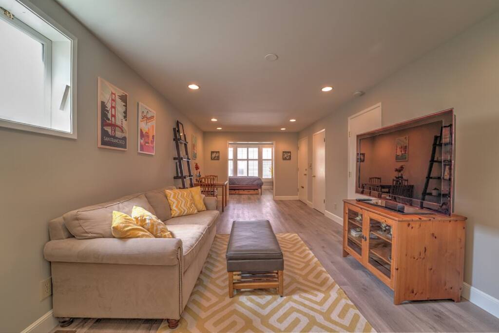 Large, light-filled living space with bedroom in distance. New hardwood floors throughout!