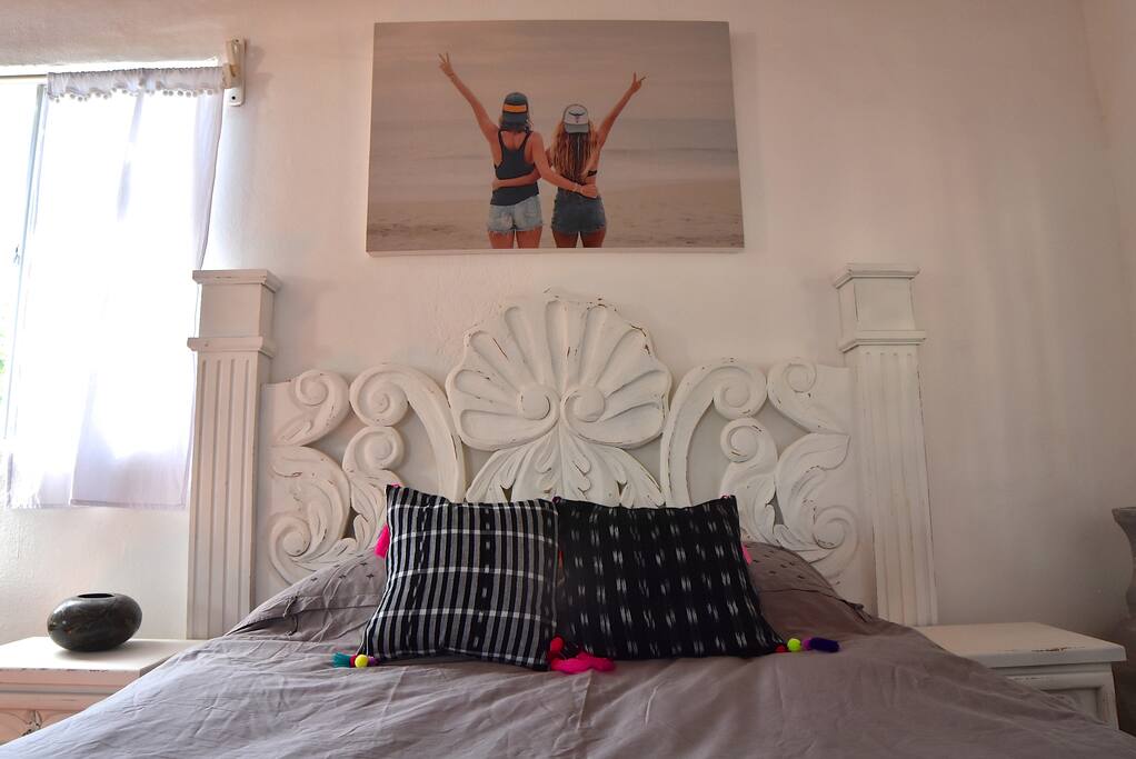 Extra comfy pillow top queen size mattress! High thread count sheets. Gorgeous hand carved headboard. Photography by Rosemary Clothing Boutique.