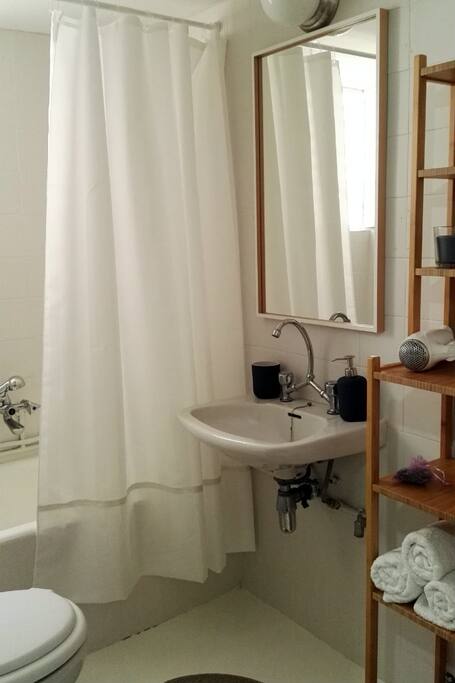 Bathroom with bathtab, fresh luxury towels, hairdrier and other amenities