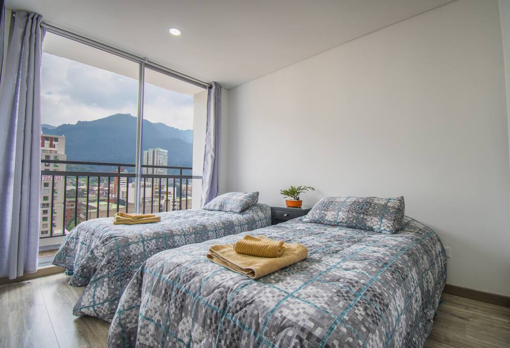 Iluminación natural en la habitación y balcón privado con vista directa a las montañas. Elige entre cama individual para dos personas o camas juntas tipo matrimonial