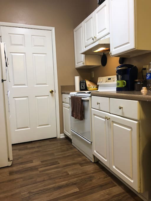 Full kitchen available stocked with pots, pans, plates, cups, and silverware . Laundry room through door.