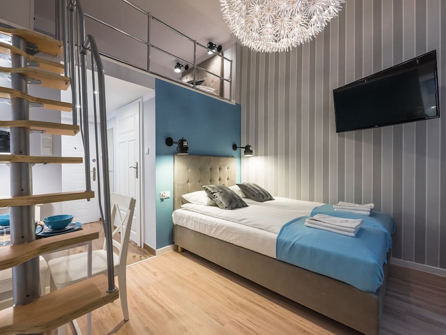 Stairs to mezzanine and two single bed combined into double bed.