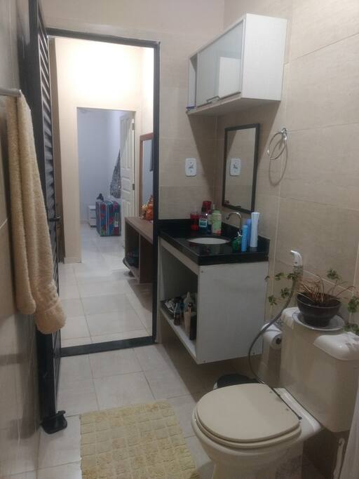 Banheiro espaçoso, limpo e organizado.