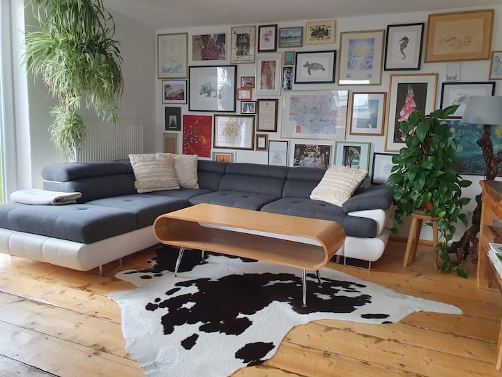 The open and individually designed living room with adjoining, open kitchen in southwest orientation.