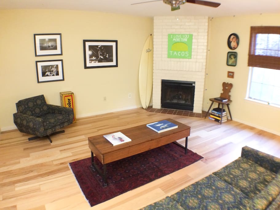 Spacious living room, with hickory floors, unique mid-century furniture, and original artwork.