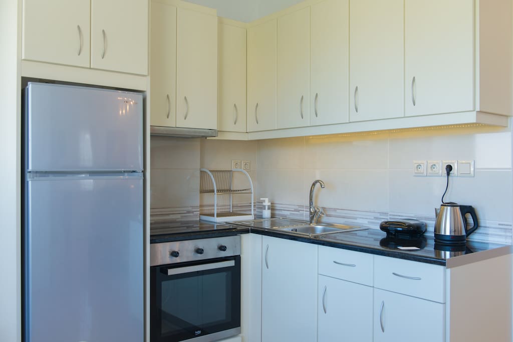 The fully equipped kitchen has kitchen utensils and crockery.