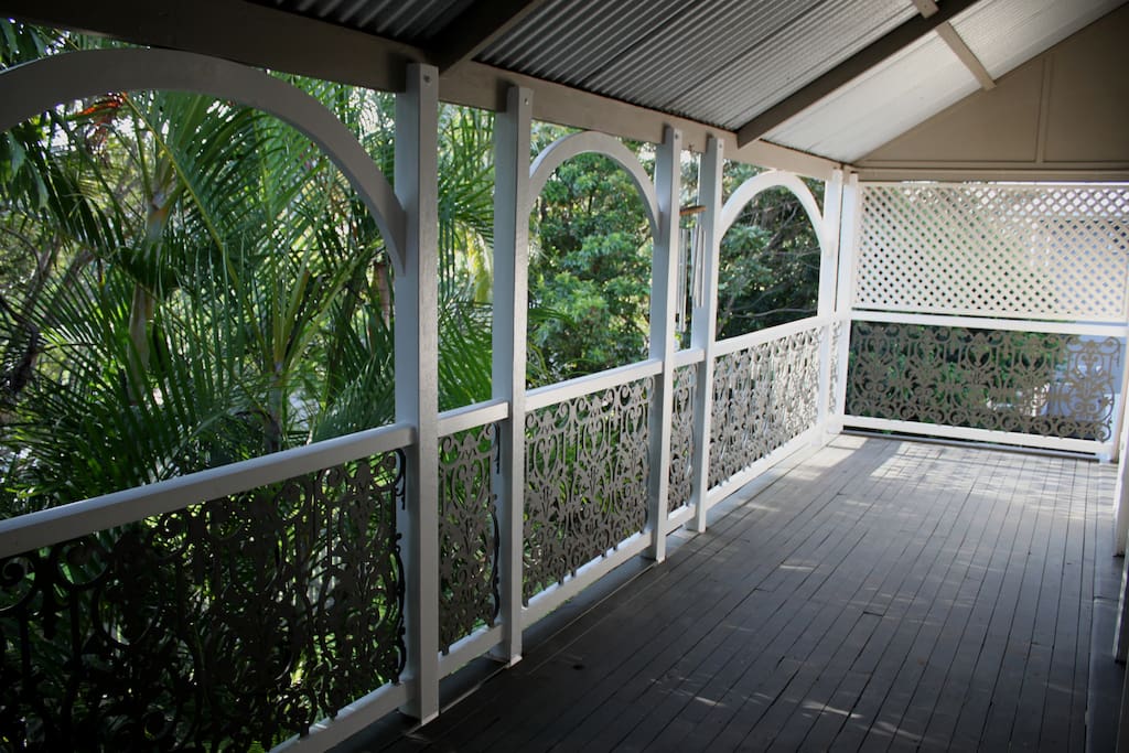 Verandah shaded by palms and tropical garden in a quiet peaceful street.