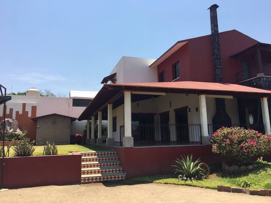 Vista lateral de terraza, área verde y al fondo baño para hombres de lado izquierdo y derecho para mujeres