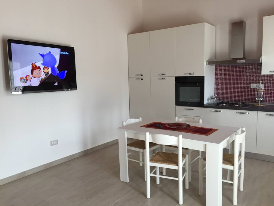 sala-cucina con tavolo e sedie - tv