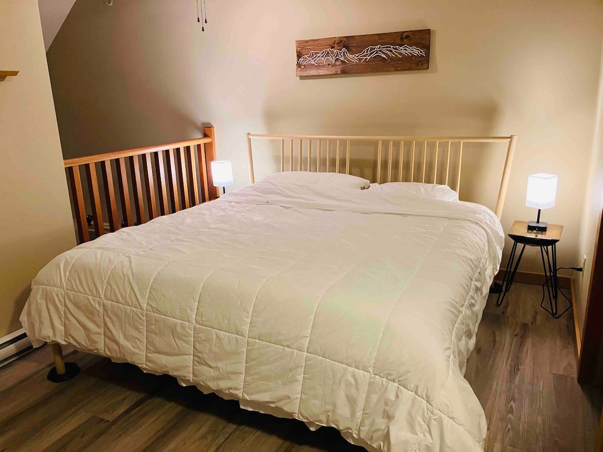 Otvorená podkrovná spálňa má robustnú manželskú posteľ s luxusným matracom z pamäťovej peny Bedgear S5. Prečítajte si naše hodnotenia a zistite, aký pohodlný je matrac!! Vlastné riečne nočné stolíky dopĺňajú izbu. 