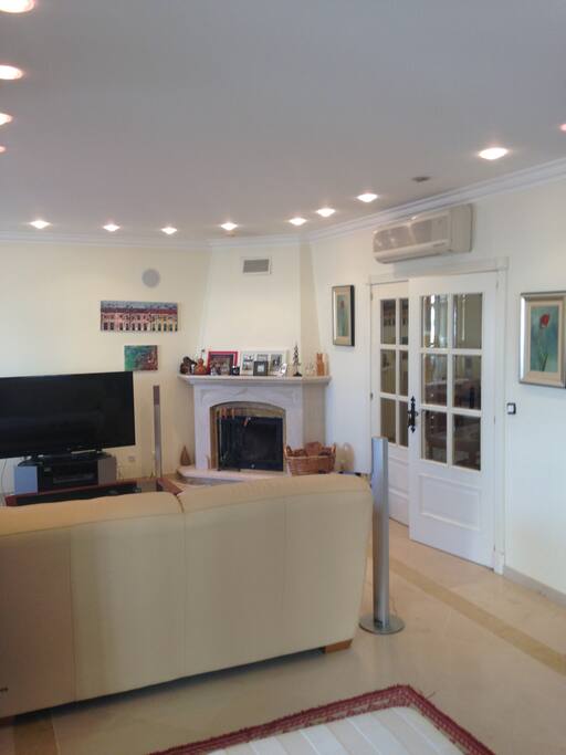 Sala de estar com acesso a sala de leitura envidraçada e terraço