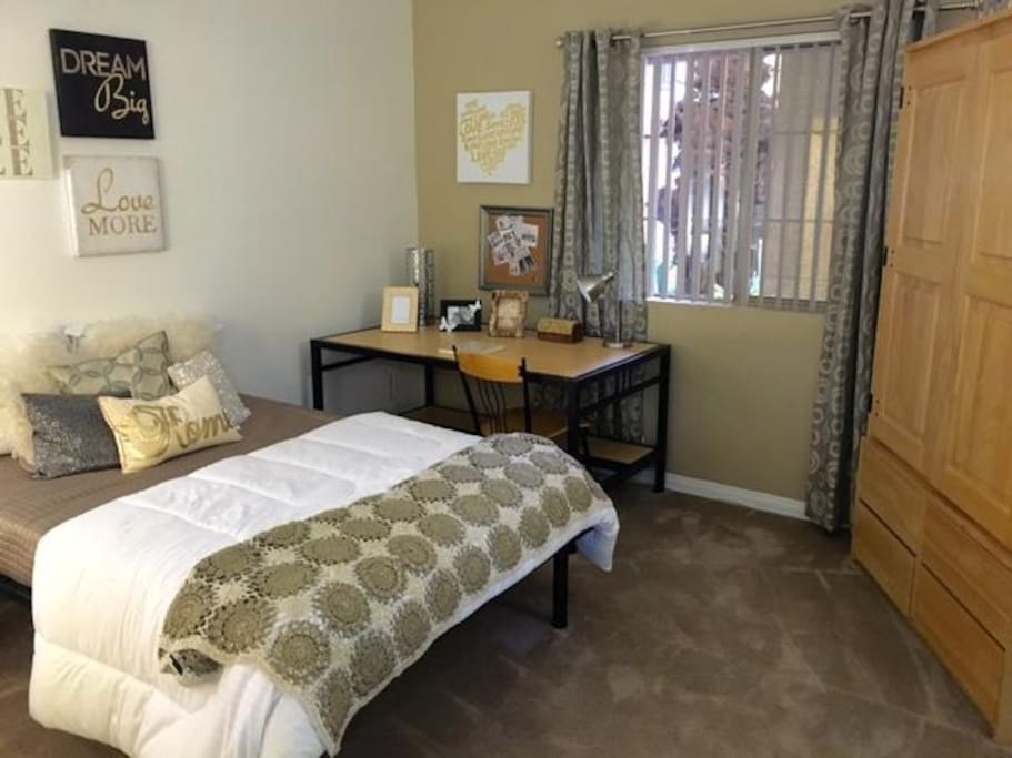 bed room with commendable furnitures including a book table, a mini desk, a chest, and a full-size bed