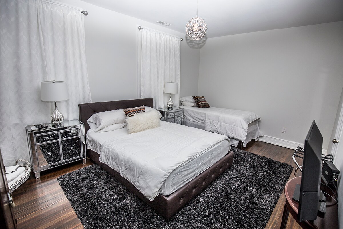 Dormitorio #2 con cama tamaño queen y dos camas individuales.