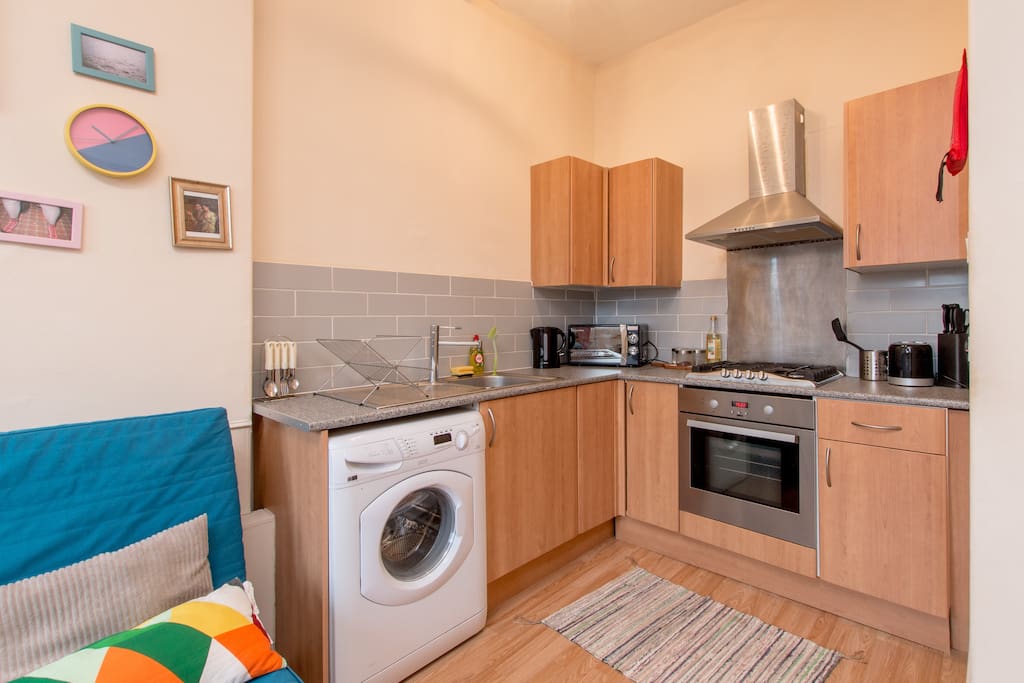 Kitchen with washing machine, microwave, toaster and kettle