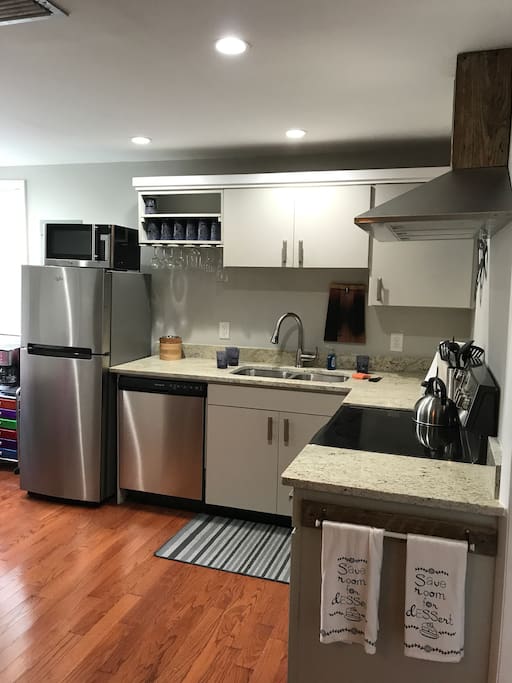 Fully stocked brand new kitchen with granite counter tops and stainless steel appliances