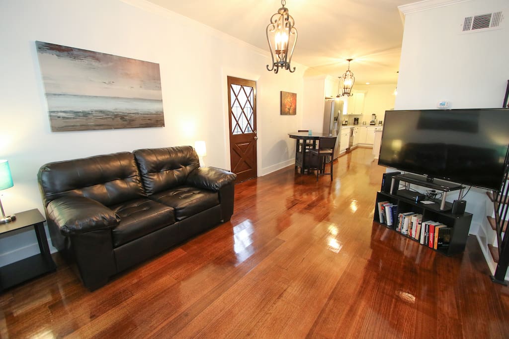 The comfy living room with large smart tv is open to the dining area and kitchen.