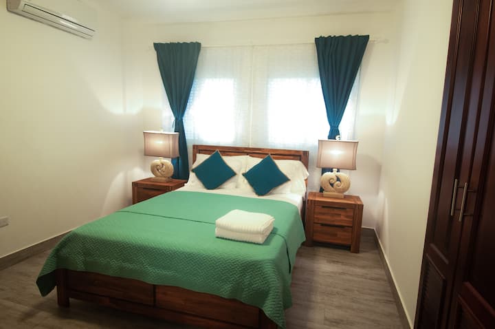 Cama principal 2, cama tamaño queen con baño privado y vistas al mar.  Fuerte aire acondicionado y ventilador de techo para dormir cómodamente.  Armarios grandes, perchas y vestidor para ropa.