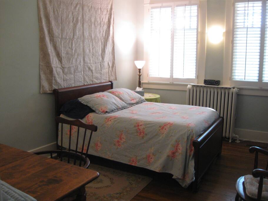 The large guest bedroom with very comfortable full size bed and wooden table.