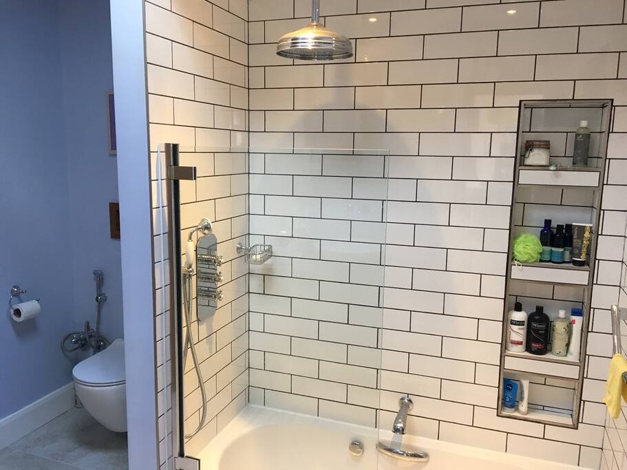 Private bathroom with rain shower and sunken tub.
