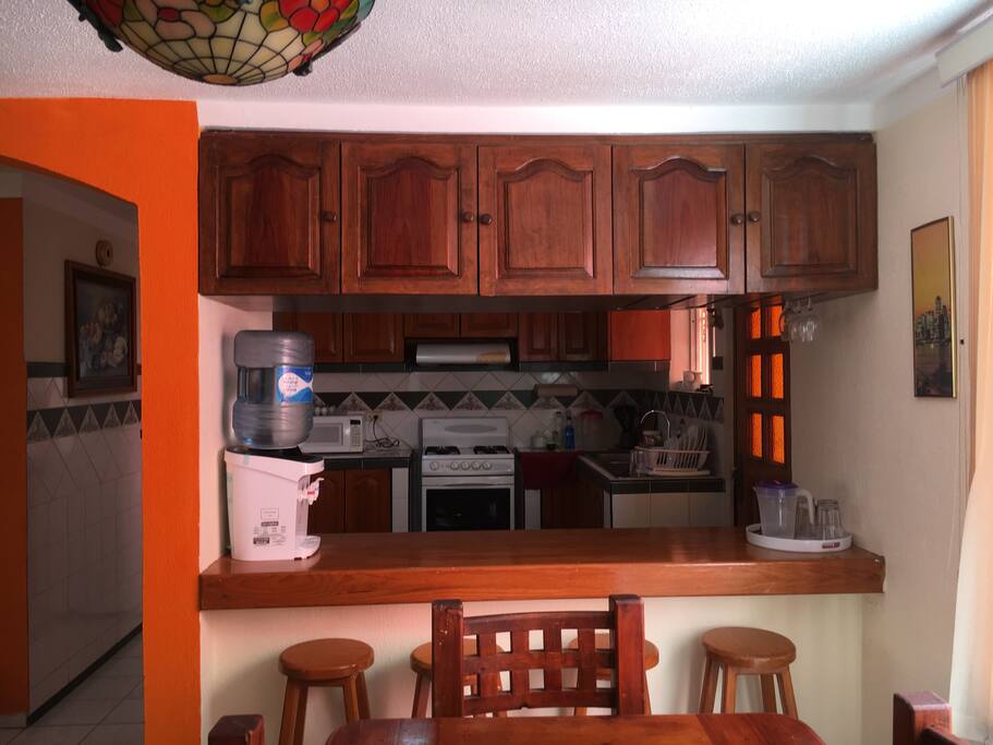 Desayunador con 4 banquetas y acceso directo a la cocina.