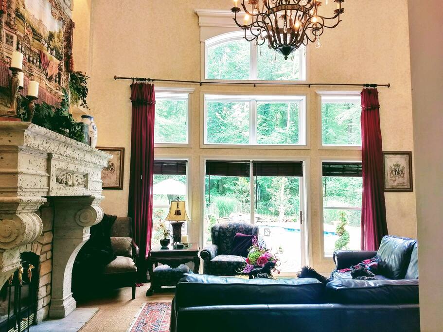 The Great Room boasts a 24' high ceiling, ample seating, wood fireplace & views to pool and terrace