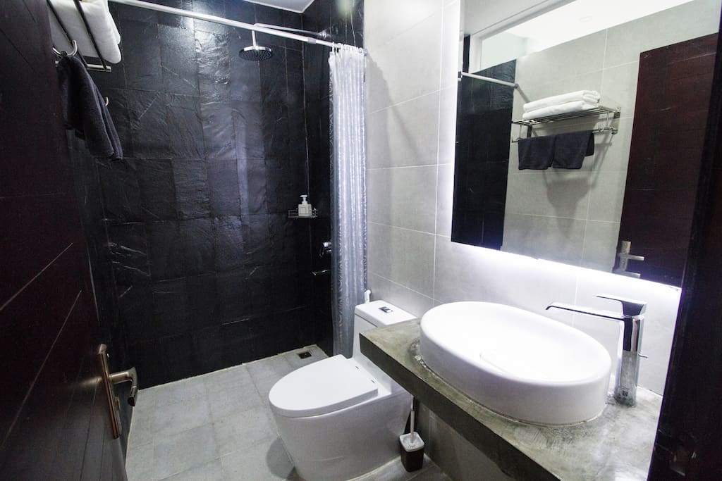Private bathroom with hot shower, mirror and towels and shampoo