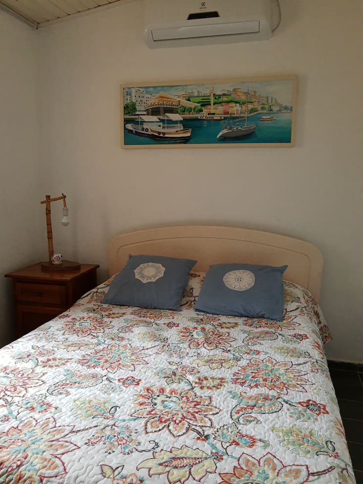 Quarto com cama de casal, climatisé et fan de teto.