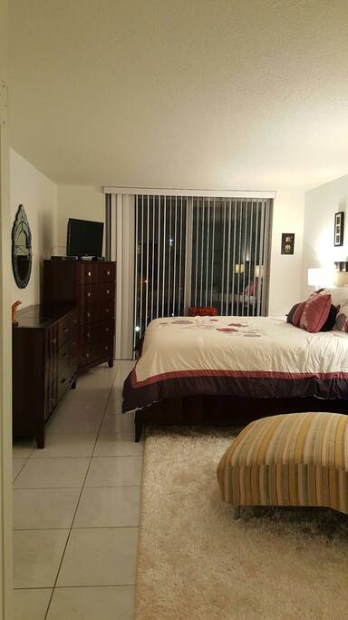 Large bedroom with balcony view. Queen-sized bed.
