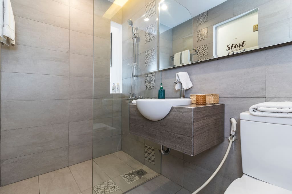 A well designed bathroom separated from the toilet by a glass wall