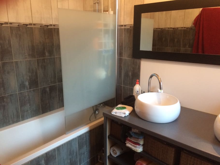 Salle de bain entièrement refaite à neuf possédant une baignoire, un double vasque, machine à laver et sèche linge à disposition. Un sèche cheveux reste à votre disposition si nécessaire.