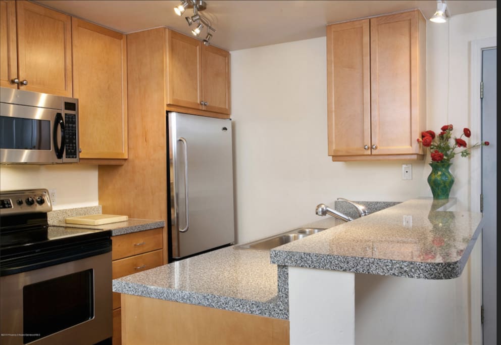 Full sized kitchen including a microwave and dishwasher