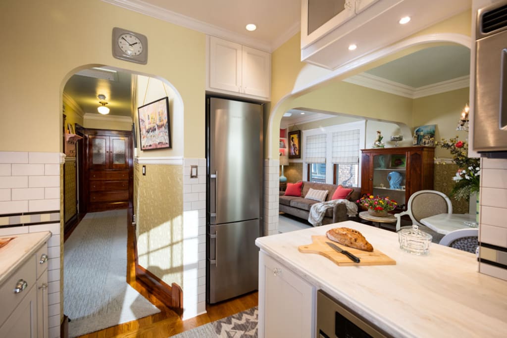 Kitchen with Leibherr refrigerator and freezer, arched openings looking into Bedroom hallway and Living Room.