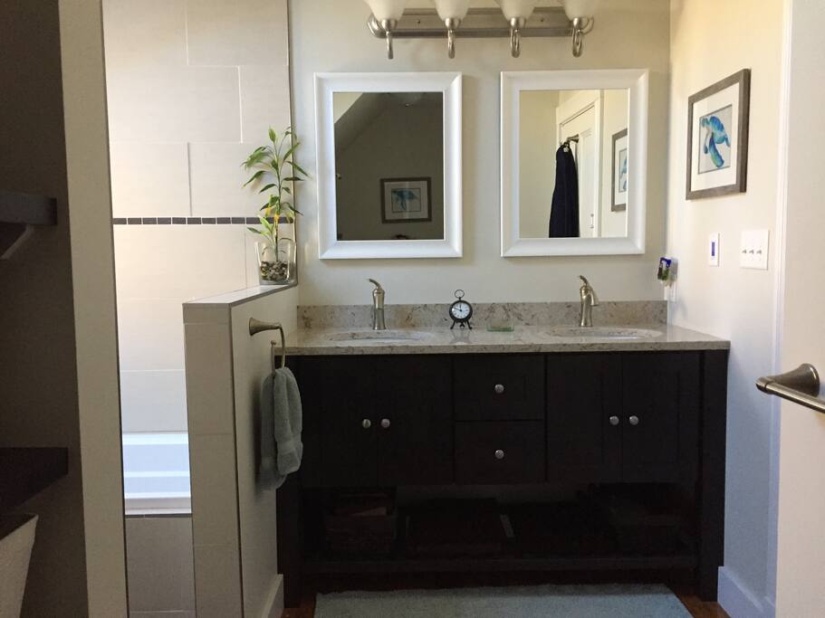 Double sinks, quartz countertops, and tons of natural light in this spacious bathroom