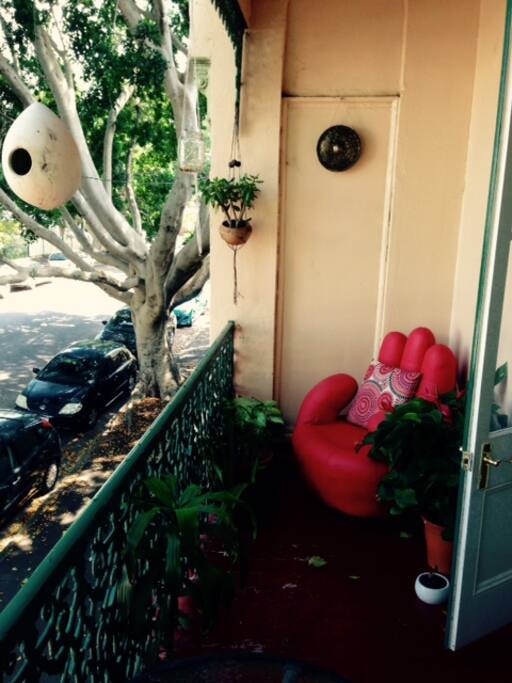 Balcony complete with candles, lounge chair and great view of the sunset filter through gorgeous old giant fig trees