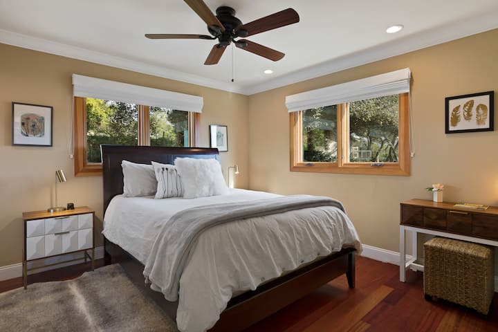 ห้องนอนที่ 2 มีเตียงควีนไซส์พัดลมเพดานตู้เสื้อผ้าขนาดใหญ่และโต๊ะทำงาน