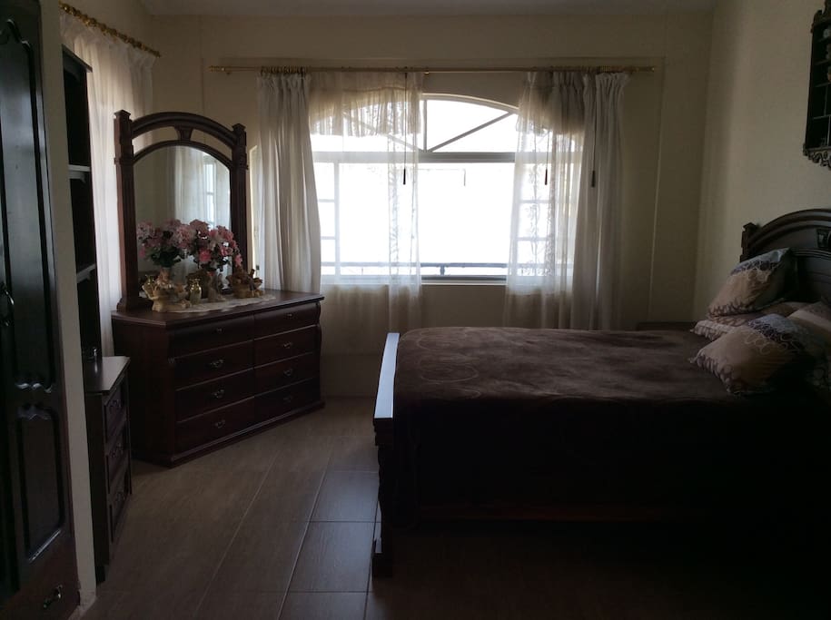 This is the bedroom with a queen size bed with two night tables on each side, a bureau, and spacious wardrobe, and ensuite bathroom.