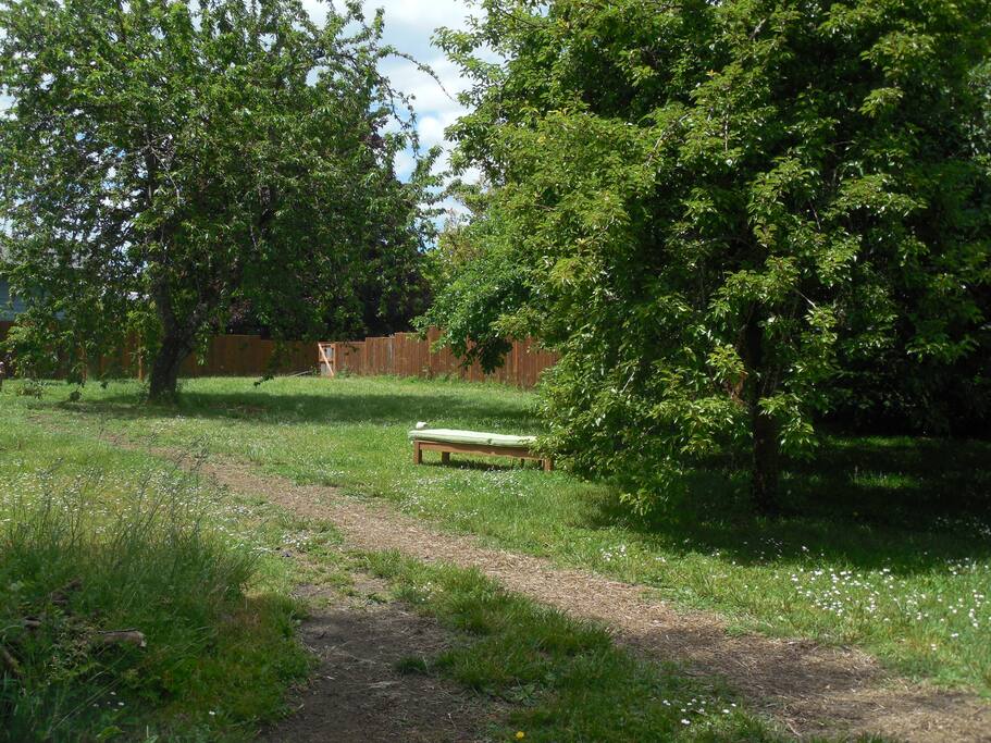 Backyard with outdoor tables, chairs, fire pit, grill and garden.