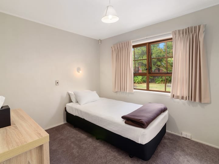 חדר שינה יחיד, עם שידת מגירות, תנור חימום וארון בגדים.