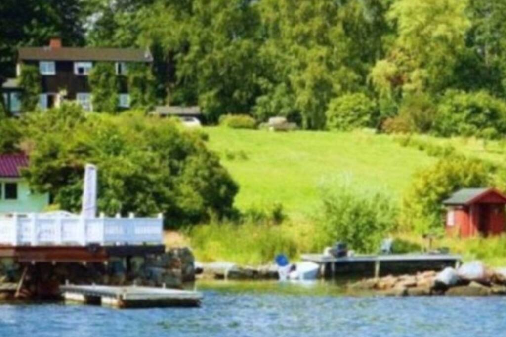 The black wooden house is filled with charm, and has a big garden, red boat house, small boat and big private beach