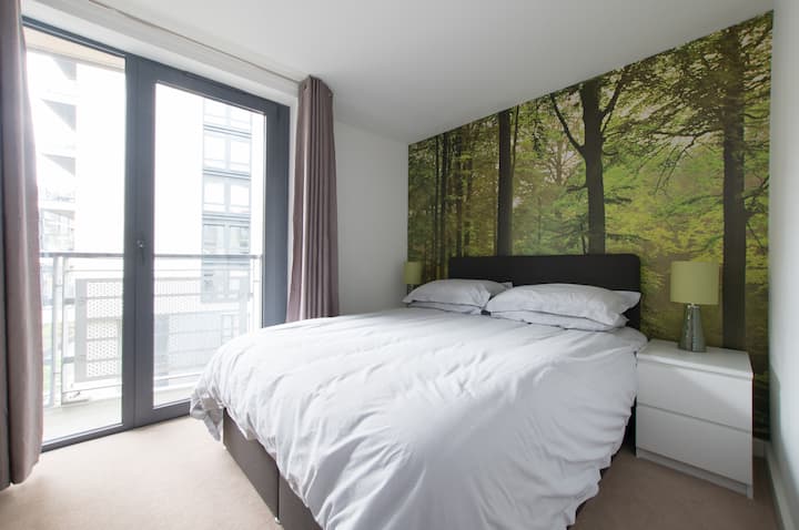 חדר שינה ראשי עם מיטת קינג סייז, מצעי כותנה, גישה למרפסת ושפע של מקום אחסון