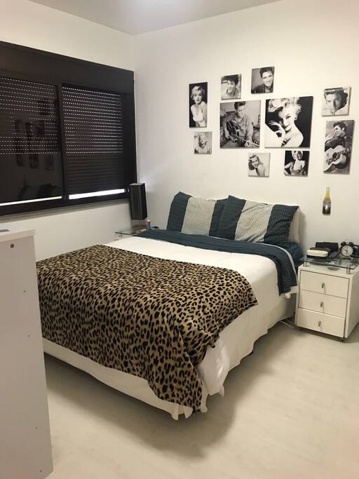 Quarto decorado, com ar condicionado e roupas de cama