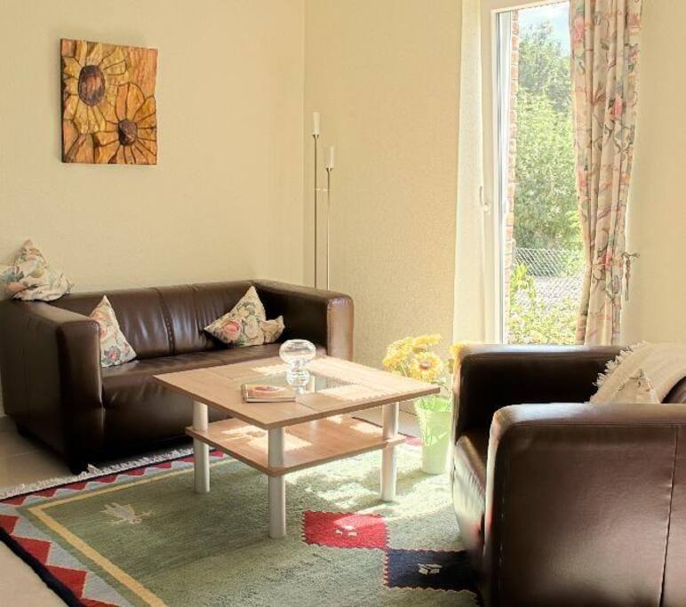 Gemütlich geschmackvoller Wohnbereich mit drei großen Terrassenfenstern in Süd-West-Ausrichtung