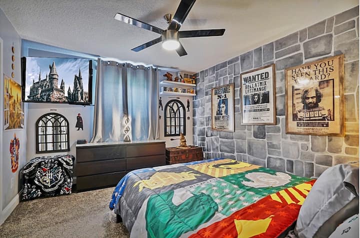 Тематска спална соба на Хари Потер со брачен кревет со 55-инчен Samsung HD паметен телевизор.